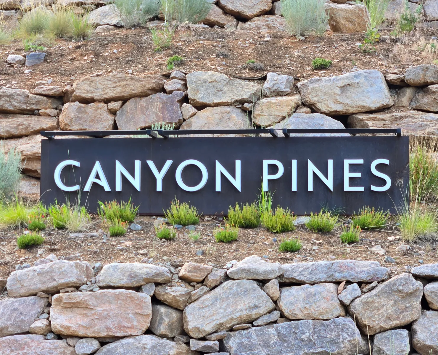 The stone entrance monument at Canyon Pines, a luxury custom mountain home community of 90 homesites on the north slope of Coal Creek Canyon in Arvada, Colorado, minutes from Golden, Boulder, and Denver. Photo by Jeff Spiker, REALTOR® with The Spiker Team at Compass, serving Arvada and the Denver Metro area.
