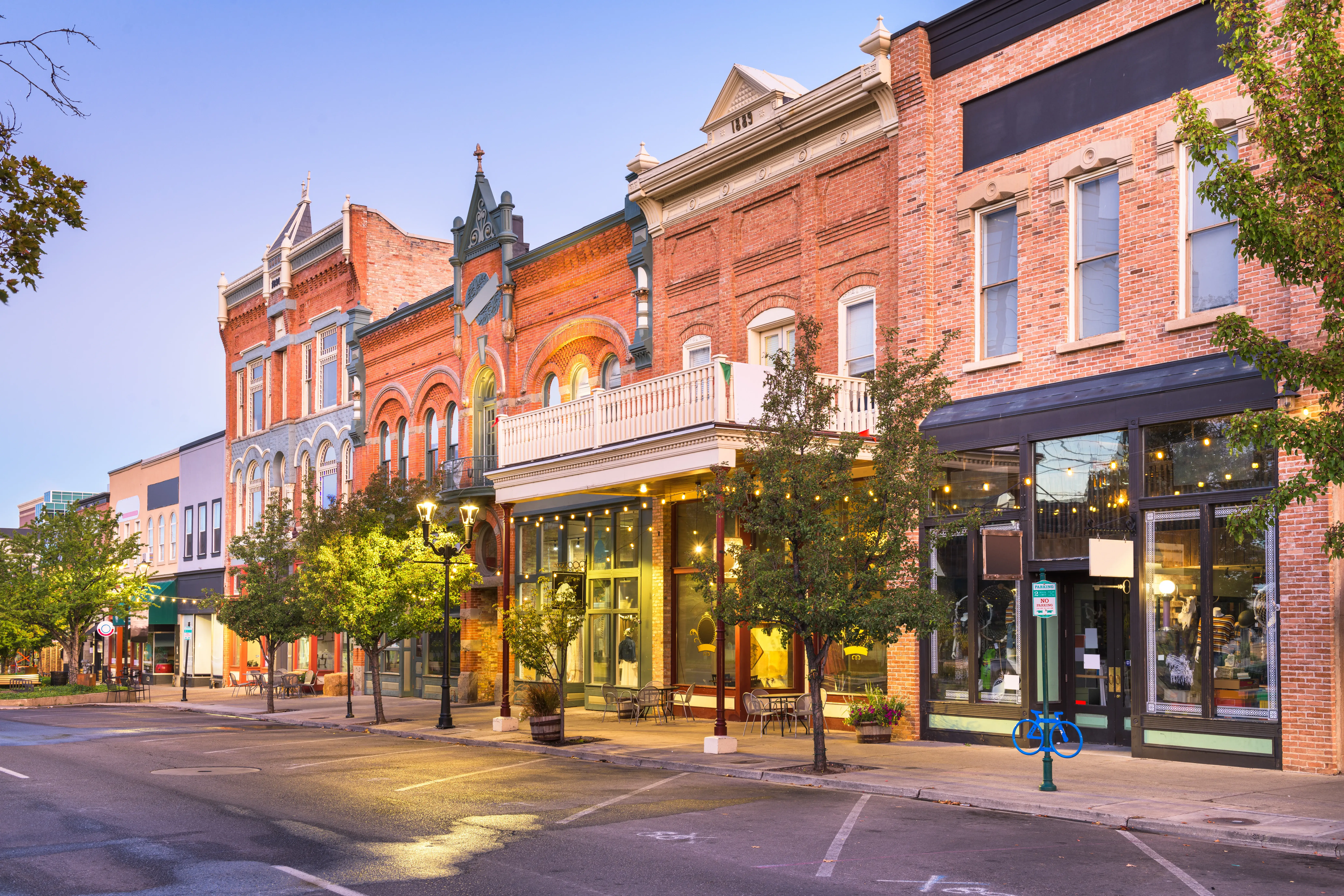 Historic brick commercial storefronts lining a downtown street at dusk