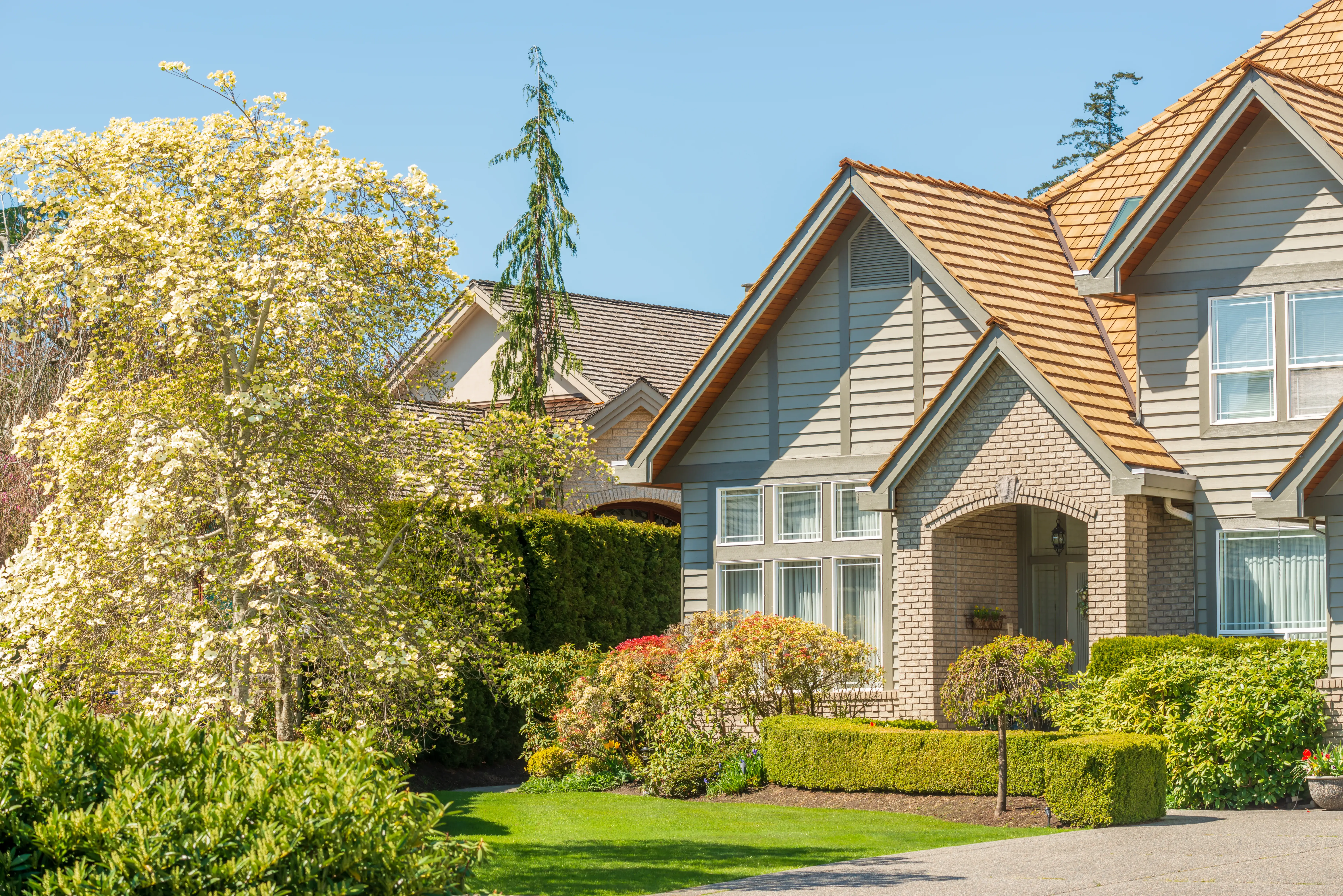 Exterior of a newly built luxury home with manicured front landscaping